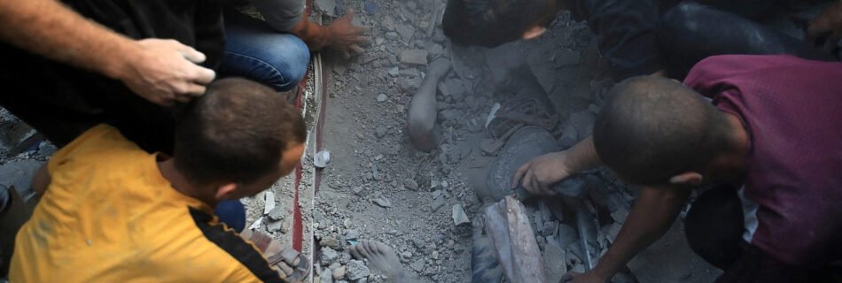 Palestinians digging with bear hands find a dead body in the rubble after an Israeli airstrike which killed dozens Palestinians in the middle of Al-Maghazi refugee camp, central Gaza Strip, November 5, 2023. (Mohammed Zaanoun/Activestills)