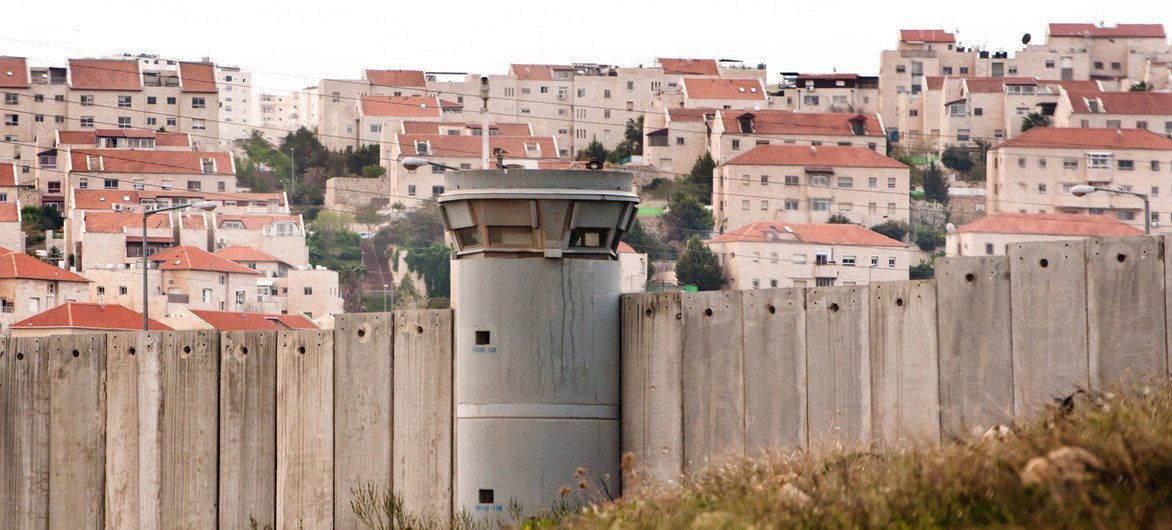 Ryan Rodrick Beiler The Separation Wall in the Occupied Palestinian Territory and behind it an Israeli settlement.